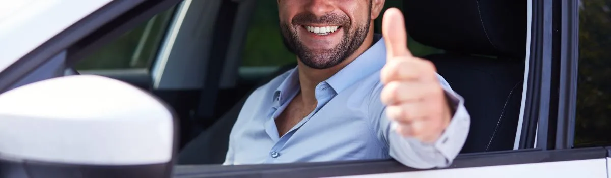 Persona dentro de un coche sonriendo