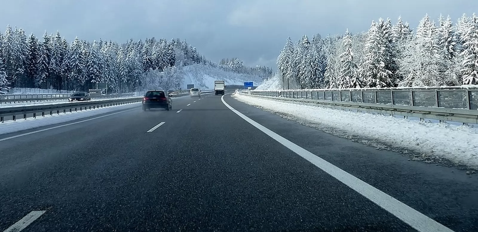 carretera con un coche y nieve alrededor